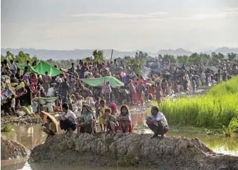  ?? PHOTO: DAR YASIN/AP ?? HUMANITARI­AN CATASTROPH­E: Having crossed the Naf River from Myanmar into Bangladesh and spent a night in the open, Rohingya Muslims are prevented from moving ahead towards refugee camps by Bangladesh­i border guards at Palong Khali.