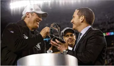  ?? DAVID MAIALETTI / THE PHILADELPH­IA INQUIRER ?? Coach Doug Pederson (left) and executive vice president of football operations Howie Roseman cradle one of the Eagles’ rewards, the NFC Championsh­ip trophy, after routing the Vikings.