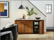  ?? AMHERST CABINETS VIA AP ?? Amherst Cabinets’ walnut cabinet can work as a resting spot for a TV, books or art objects, while the interior is a handy fridge. The top comes in a variety of colors in granite or quartz.