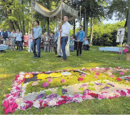  ?? FOTO: MICHAEL HESCHELER ?? Ehemalige Ministrant­en tragen den Himmel unter dem Dekan Stefan Schmid mit der Monstranz an der Fronleichn­amsprozess­ion teilnimmt.