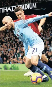  ??  ?? Manchester City’s David Silva opened the scoring in the Manchester derby yesterday despite the best efforts of Manchester United’s Ander Herrera. City won 3-1. | Reuters