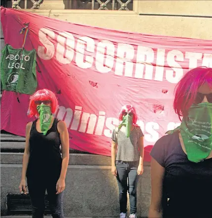  ??  ?? PELUCAS ROSADAS. Es el distintivo que las identifica. En la foto, socorrista­s platenses que cuentan sus experienci­as cubren sus caras con los pañuelos verdes por el aborto legal.