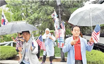  ??  ?? Supporters of Park wave US and South Korean flags during a protest demanding her release from prison, outside the Seoul Central District Court in Seoul. — AFP photo