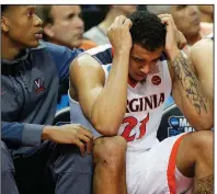  ?? AP/BOB LEVERONE ?? Virginia guard Isaiah Wilkins (21) is consoled by a teammate after fouling out during the second half of the Cavaliers’ 74-54 loss to Maryland-Baltimore County on Friday in Charlotte, N.C.