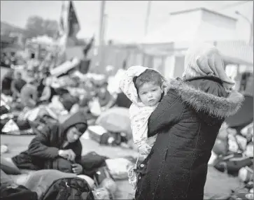  ?? Louisa Gouliamaki
AFP/ Getty I mages ?? A SYRIAN WOMAN and her child at the main port on the Greek island of Chios, where protesters gathered. The plan to send migrants from Greece to Turkey has drawn criticism from human rights groups.