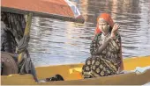  ?? — PTI ?? A tourist embarks on a shikara ride while posing for a photograph in an empty Dal Lake in Srinagar on Thursday. The government has withdrawn its advisory, issued on August 2 asking tourists in the Valley to leave.