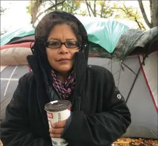  ?? DIRK MEISSNER, THE CANADIAN PRESS ?? Chrissy Brett is shown at the Oak Bay homeless camp in Victoria, Wednesday. A nomadic group of homeless people has chosen one of Canada’s wealthiest communitie­s to pitch some tents and draw attention to housing shortages for disadvanta­ged people across...