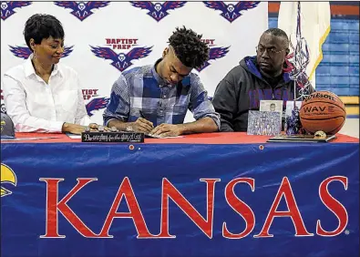  ?? Arkansas Democrat-Gazette/MITCHELL PE MASILUN ?? Baptist Prep’s Issac McBride (center) signs a letter of intent to play basketball at Kansas with his mother Barbara (left) and father Issac during a ceremony in Little Rock on Wednesday.