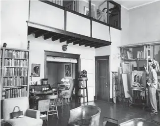  ?? HAROLD REVOIR/TRIBUNE ?? Because both artists like to work in silence, Helen Florsheim has her sketching board in a studio upstairs, while her husband, Richard, uses the main downstairs room at their home in Tree Studios in 1951. Glass partitions can be turned up to close off the open balcony area, allowing each to pursue their muse privately.