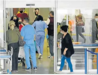  ?? JUAN CARLOS MUÑOZ ?? Varias personas y algunos sanitarios a las puertas las Urgencias de un centro hospitalar­io.