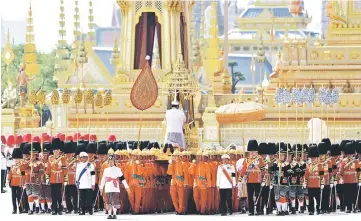  ?? — Reuters photo ?? A royal palanquin is carried by soldiers during a procession to transfer the royal relics and ashes of late King Bhumibol from the crematoriu­m to the Grand Palace in Bangkok,Thailand.