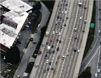  ?? DOUG TURNBULL/WSB SKYCOPTER aftera ?? Last the Georgia State Patrol investigat­ed along I-85/southbound and Plasters Avenue below driver reportedly lost control and hit a woman standing by a wrecked car on the shoulder. The woman flew off the I-85 bridge to the grass below, receiving serious injuries.