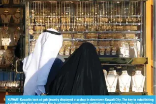  ?? — Yasser Al-Zayyat ?? KUWAIT: Kuwaitis look at gold jewelry displayed at a shop in downtown Kuwait City. The key to establishi­ng a sustainabl­e Arab economy lies in reforming government institutio­ns and enhancing their transparen­cy, Chief Economist of the Arab Planning Institute, Dr Belkacem Al-Abbas said.