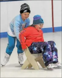  ?? GENE WALSH — DIGITAL FIRST MEDIA ?? Child pushes a friend across the ice on a chair at the Thomas Eccleston Jr. Rink during free community skating at The Hill School in Pottstown.