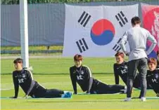  ?? AP ?? South Korea’s Kim Young-gwon (second from left) and Son Heung-min (left) stretch during a training session.
