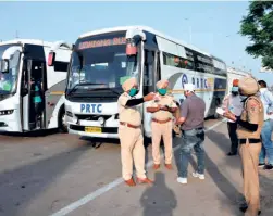  ??  ?? POLICEMEN recording details of passengers travelling in a bus that carried people back to Punjab from Nanded in Maharashtr­a. The passengers were to be subjected to a mandatory 21-day quarantine.