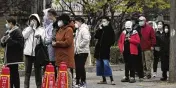  ?? NG HAN GUAN/AP ?? Residents line up for COVID tests in Beijing on Thursday. China is expanding lockdowns as its number of COVID-19 cases hit a daily record.