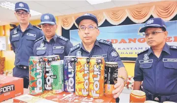  ??  ?? Johari shows the seized liquor during the press con��erence in Alor Setar, Kedah yesterday. — Bernama photo