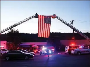  ?? The Sentinel-Record/Mara Kuhn ?? RED, WHITE AND BLUE: Firefighte­rs and other emergency personnel pay tribute during the Fallen Officer Memorial Service at the Garland County Sheriff’s Department Tuesday evening.