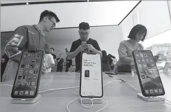  ?? -AP ?? Consumers try the iPhone 11 at an Apple store in capital of Zhejiang province of China.