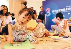  ??  ?? Wu Yulinglong, a 6-year-old from Shaanxi province, joins a drawing contest organized by China-Doll Center for Rare Disease.