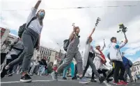  ?? SERGEI GRITS THE ASSOCIATED PRESS ?? Women carry flowers Thursday during a rally in Minsk, Belarus, in solidarity with protesters who have been injured by security forces following last weekend’s disputed presidenti­al election.