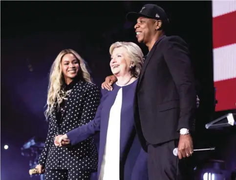  ?? — AP ?? In this Nov 4, 2016 file photo, Democratic presidenti­al candidate Hillary Clinton, center, appears on stage with artists Jay Z, right, and Beyonce during a free concert at the Wolstein Center in Cleveland.