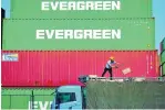  ?? CHINATOPIX ?? A worker loads imported goods on a truck earlier this month at a distributi­on company outside the container port in Qingdao, in east China’s Shandong province.