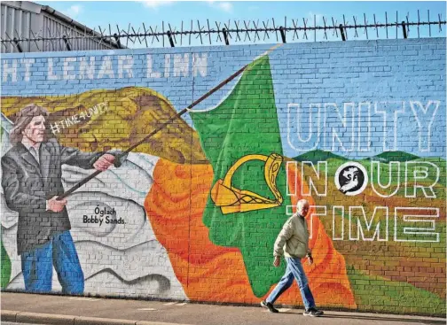  ?? Tribune News Service ?? A man walks past a mural calling for Irish unity on the day that the Northern Ireland census was released in Belfast, Northern Ireland.