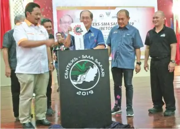  ??  ?? Uggah performs a gimmick to mark the launch of Centexs-SMA Safari 2019. He is flanked by Rentap (second right) and Syeed Mohd Hussien.