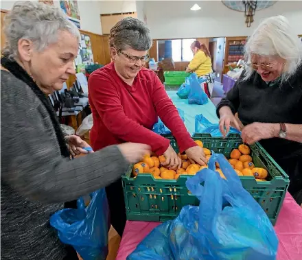  ?? PHOTO: MURRAY WILSON/STUFF ?? Foodtogeth­er at St Matthew’s Church, Awapuni, celebrates its first year of operation, with volunteer sorters, left, Rosemary Krsinich, Merralyne Estall and Clare Woodbury.