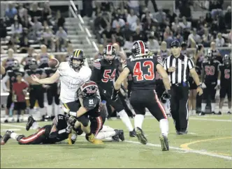  ?? Nikolas Samuels/The Signal (See additional photos on signalscv.com) ?? Hart players Trevor Laibl (21) and Jacob Jaramillo (51) tackle Ventura player Cannon Reid (14), causing him to fumble the football at Canyon High School on Thursday, Sept. 28.