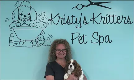  ?? BILL DEBUS - THE NEWS-HERALD ?? Kristy Sammet, owner of Kristy’s Kritters Pet Spa, poses for a photo with one of her dogs, Louie, inside the Madison Village business. Sammet has operated the dog-grooming salon for 19 years.