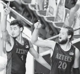  ?? ROSS D. FRANKLIN AP ?? SDSU’s Jordan Schakel (20) and Trey Pulliam wave to the few Aztecs fans in attendance after beating Arizona State. Schakel had a career-high 25 points.