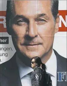  ?? Sean Gallup/Getty Images ?? A woman walks past an election campaign billboard that shows Heinz-Christian Strache, lead candidate of the rightwing Austria Freedom Party, on Saturday in Vienna, Austria.