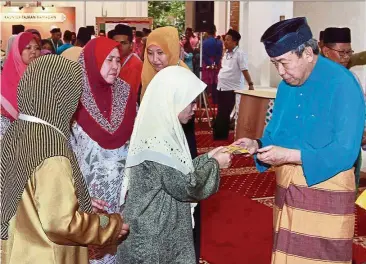  ??  ?? Sultan Sharafuddi­n presenting Raya aid to the poor during the ‘buka puasa’ event at Masjid Diraja Tengku Ampuan Jemaah Bukit Jelutong near Shah Alam In June this year.