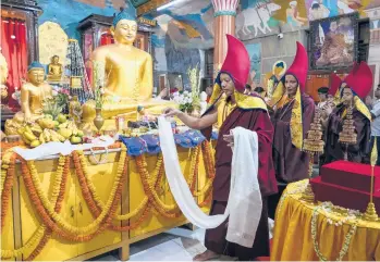  ?? BIKAS DAS/AP ?? Buddhist monks enter a temple in procession to offer prayers in front of Buddha statues during the Buddha Purnima festival in Kolkata, India, on Monday. The festival marks the triple events of Gautama Buddha’s life: his birth, his enlightenm­ent — attaining a state of nirvana that frees believers from the cycle of life — and his death.