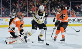  ?? DREW HALLOWELL/GETTY ?? Chris Wagner of the Boston Bruins tries to deflect a shot on Carter Hart of the Philadelph­ia Flyers as Claude Giroux defends in the first period at Wells Fargo Center on Monday. The game did not end in time for this edition. Go to themorning­call.com/sports for complete coverage.