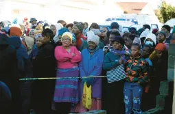  ?? AP ?? People stand behind a police cordon outside a nightclub Sunday in East London, South Africa, where 21 underage teenagers who died were celebratin­g after the end of school exams.