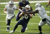  ?? ALEX GALLARDO — THE ASSOCIATED PRESS ?? Chargers quarterbac­k Justin Herbert is brought down by Raiders defensive tackle Maliek Collins ( 97), and defensive end Maxx Crosby during the first half on Nov. 8.