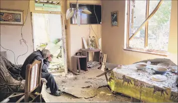  ?? Associated Press photo ?? Yury Melkonyan, 64, sits in his house damaged by shelling from Azerbaijan's artillery during a military conflict in Shosh village outside Stepanaker­t on Saturday.