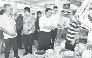  ??  ?? TURUN PADANG: Chong melawat peniaga di Pasar Komuniti Stutong di Kuching, semalam. Turut kelihatan Ahli Parlimen Bandar Kuching Dr Kelvin Yii.
