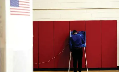  ??  ?? A voter completes his ballot inside a privacy booth at a polling station inside Knapp elementary school on election day in Racine, Wisconsin, 3 November. Photograph: Bing Guan/Reuters