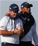  ?? AP PHOTO ?? SUNK: Tiger Woods puts his arm around Patrick Reed as they walk the seventh hole during the Ryder Cup Sunday.