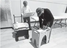  ?? Jenny Sparks, Loveland Reporter-Herald ?? Christian Becerra, right, and Mary Connole, both with the nonprofit CreatorSpa­ce, put together a desk Monday at the House of Neighborly Service in Loveland.