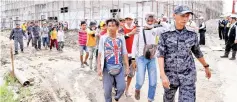  ??  ?? The illegal immigrants working at a constructi­on site in Sandakan being led away by Immigratio­n officers during a joint operation with the Constructi­on Industry Developmen­t Board. - Bernama photo