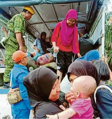  ??  ?? OPERASI menghantar pulang mangsa banjir dari PSS Kampung Selagon.