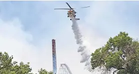  ?? RICK MCCLURE/AP ?? A helicopter drops water on the brush fire Sunday.