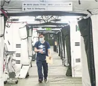  ?? CHRIS YOUNG THE CANADIAN PRESS FILE PHOTO ?? A worker walks through Sunnybrook’s field hospital. As of Tuesday, 130 COVID patients were in hospital in Ontario.