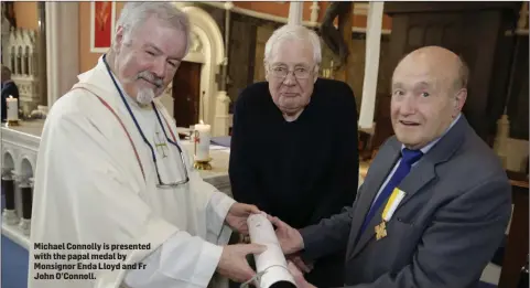  ??  ?? Michael Connolly is presented with the papal medal by Monsignor Enda Lloyd and Fr John O’Connoll.